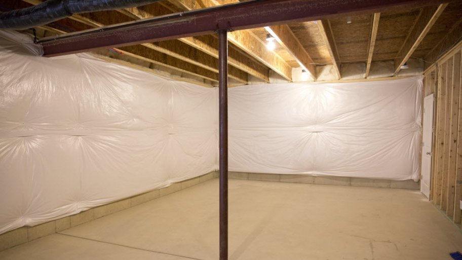 Load-bearing metal wall beam with supporting post in unfinished basement